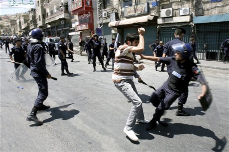 Jordanian police beat a protester during a demonstration demanding reforms and the resignation of their prime minister, in Amman, Jordan, on Friday, July 15.